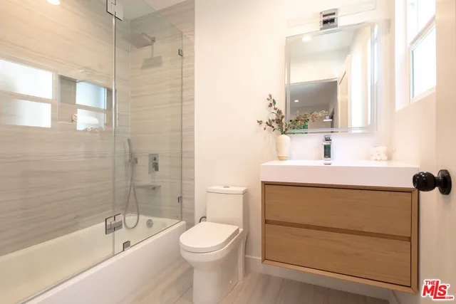 a bathroom with a bathtub a sink a toilet and a mirror