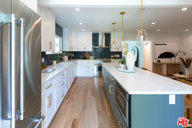 a large kitchen with stainless steel appliances kitchen island a stove a sink a refrigerator and a cabinets