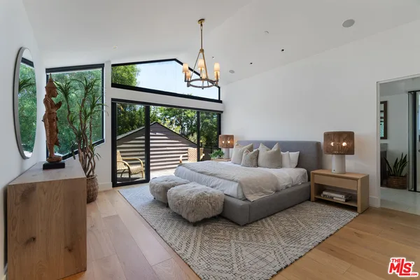 a spacious bedroom with a bed and a large window