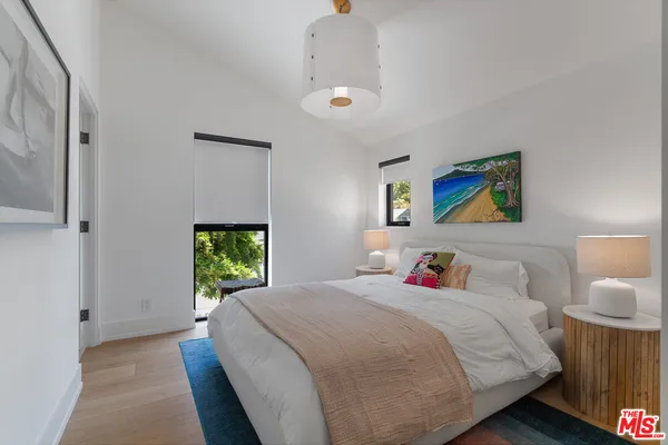 a bedroom with a bed and painting on the wall