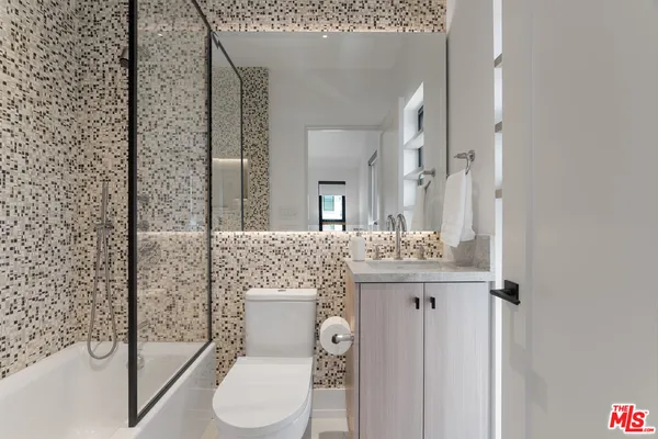 a bathroom with a granite countertop sink toilet and shower