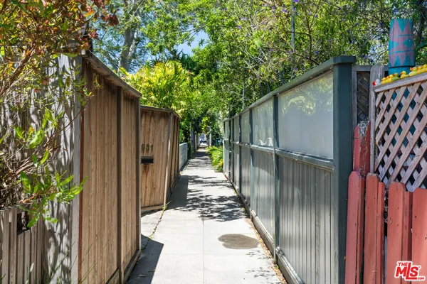 a view of a pathway of a house with wooden fence