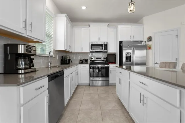 a large kitchen with stainless steel appliances granite countertop a stove a sink dishwasher and a refrigerator