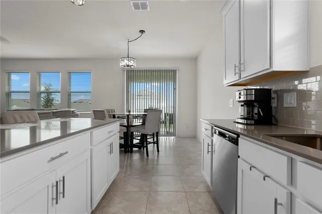 a kitchen with granite countertop a sink a counter space appliances and cabinets