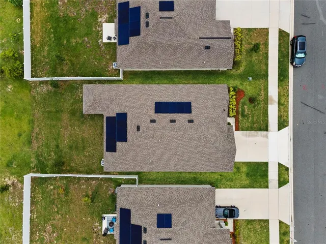 an aerial view of a house with a yard