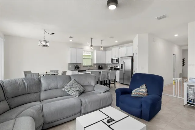 a living room with furniture kitchen and a chandelier