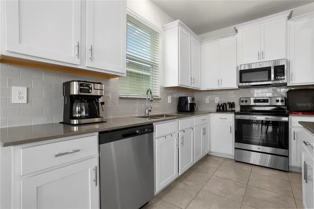 a kitchen with cabinets appliances and a window