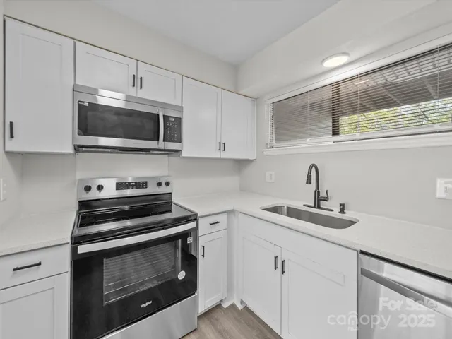 a kitchen with cabinets stainless steel appliances and a sink