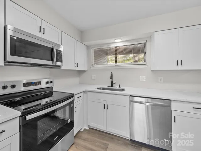 a kitchen with white cabinets and a stove