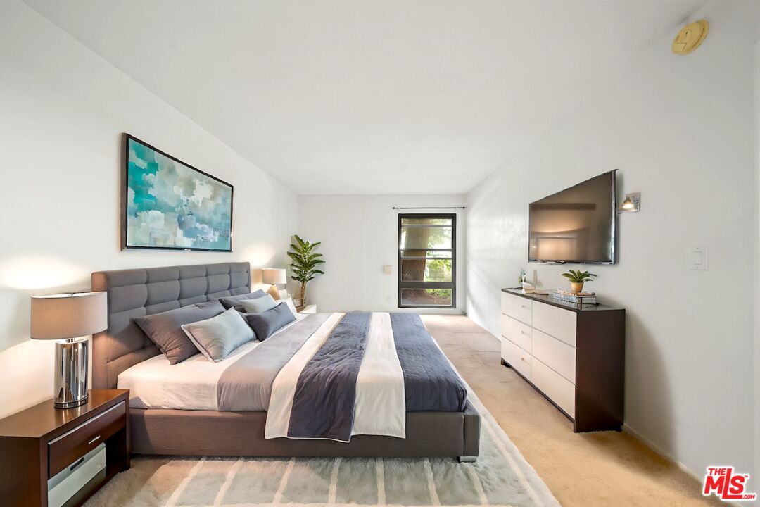 7765 West 91st Street, Unit F1110 Playa del Rey, CA 90293 - Photo 11 of 22 a bedroom with a bed and a flat screen tv