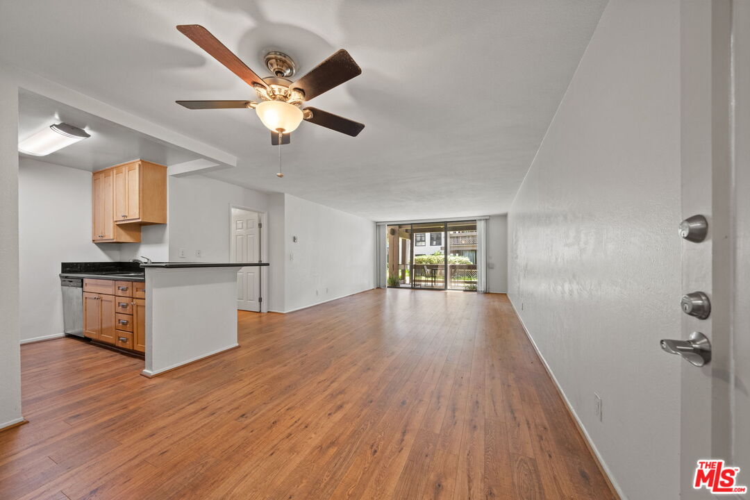 7765 West 91st Street, Unit F1110 Playa del Rey, CA 90293 - Photo 3 of 22 a view of empty room with wooden floor and ceiling fan