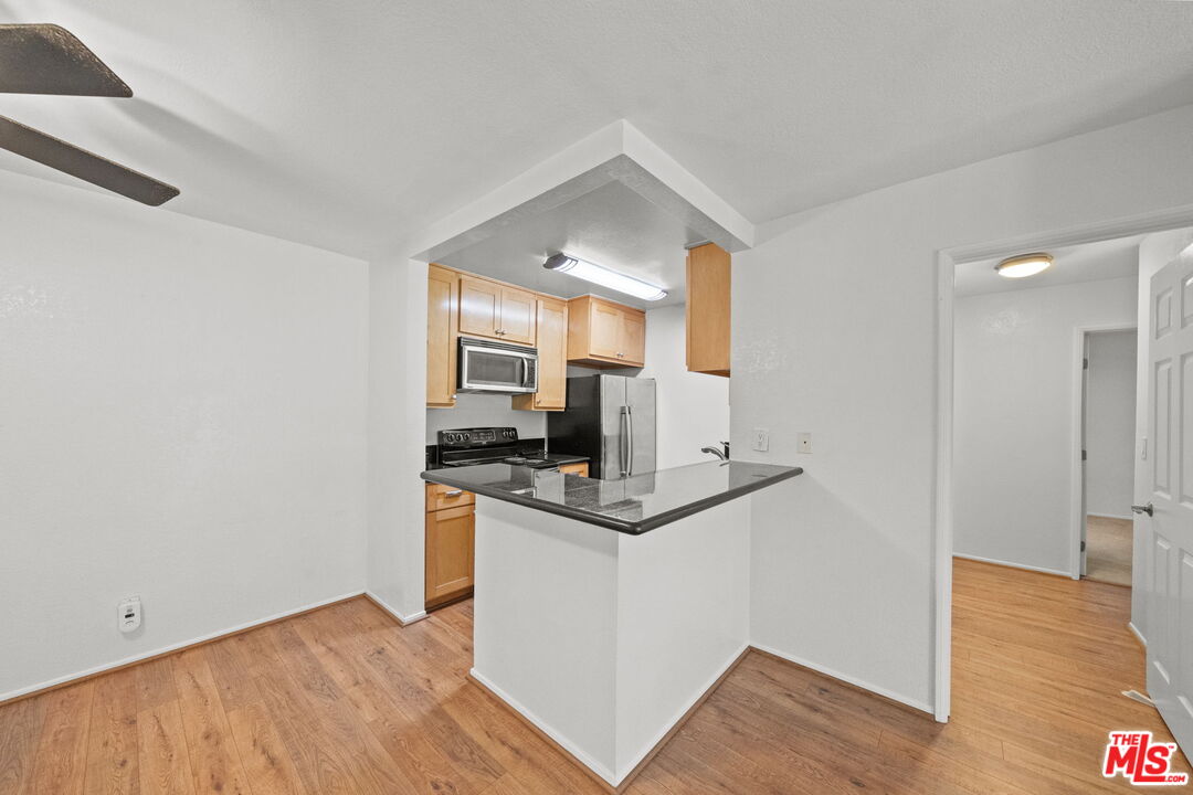 7765 West 91st Street, Unit F1110 Playa del Rey, CA 90293 - Photo 6 of 22 a kitchen with stainless steel appliances granite countertop a stove and a refrigerator