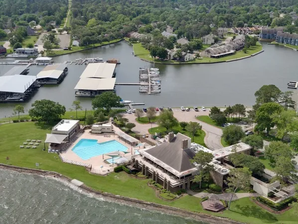 an aerial view of a house with swimming pool and outdoor seating