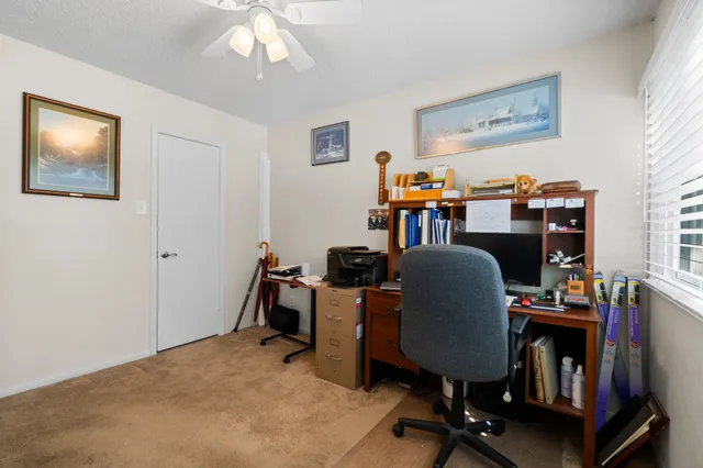 a view of a workspace with furniture and a window