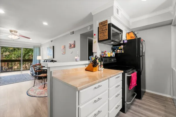 a kitchen with stainless steel appliances granite countertop a sink and a white wooden cabinets