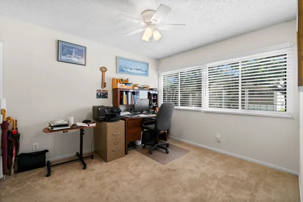 a view of a workspace with furniture and a window