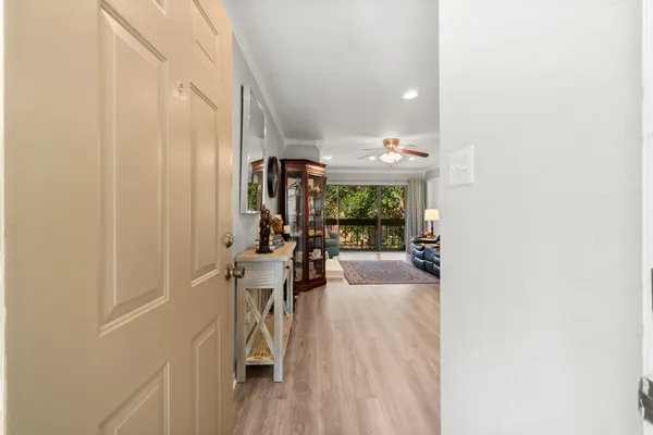 a view of a hallway with dining room and furniture