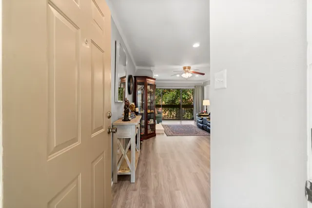 a view of a hallway with dining room and furniture