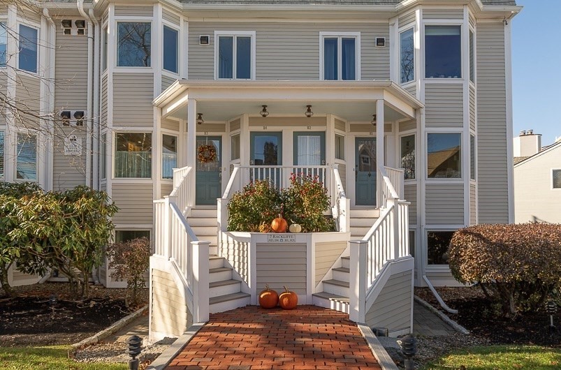 a view of a house with a small yard and potted plants