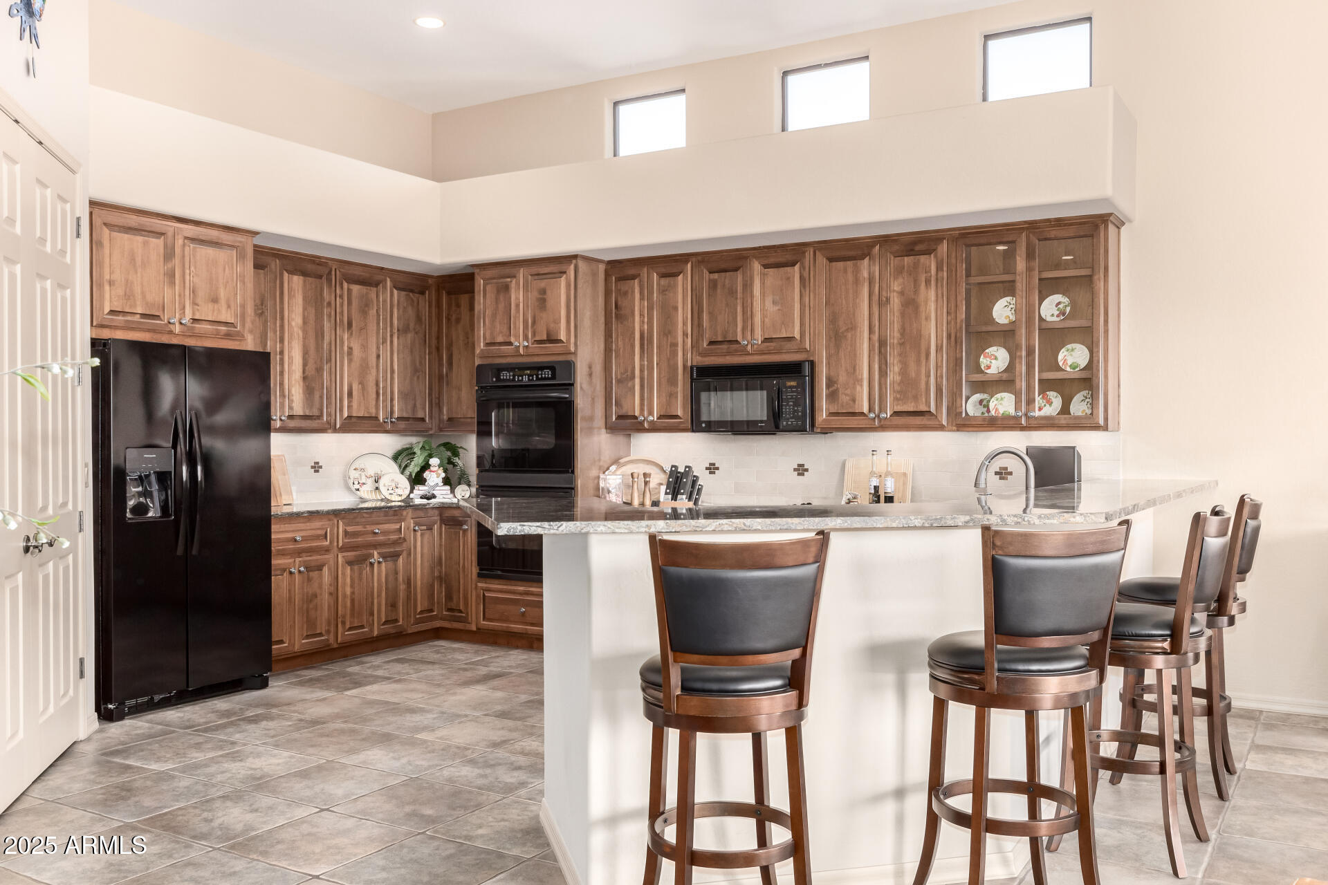 a kitchen with a refrigerator and a stove top oven