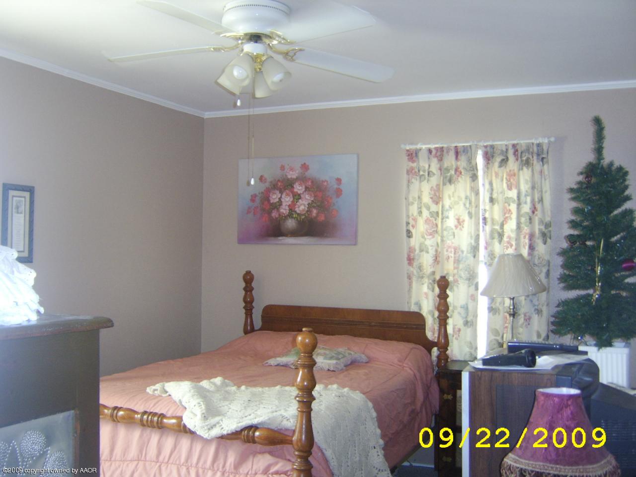 4706 South Bonham Street Amarillo, TX 79110 - Photo 6 of 9 a bedroom with a bed and a chandelier