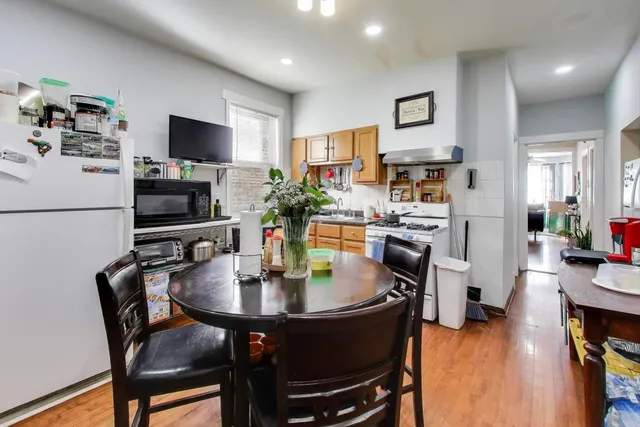 a kitchen with stainless steel appliances granite countertop a dining table and chairs