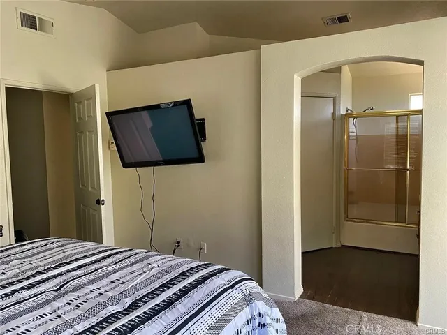 a bedroom with a bed and flat screen tv