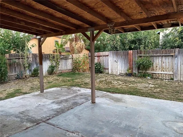 a backyard of a house with a tree and wooden fence