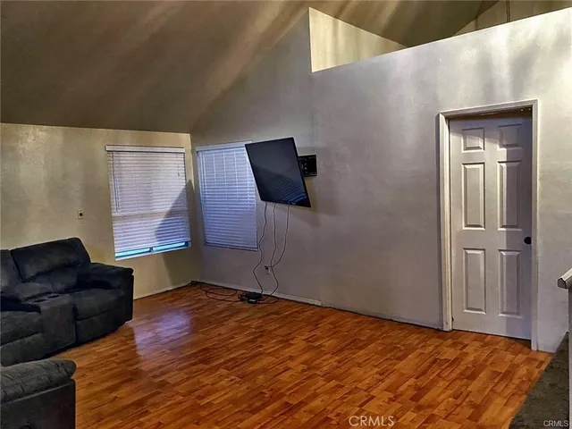 a view of an empty room with wooden floor and cabinet