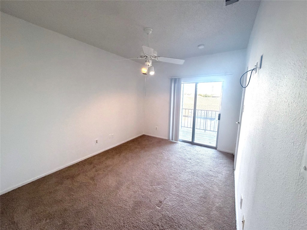 12166 Metric Boulevard, Unit 339 Austin, TX 78758 - Photo 7 of 13 an empty room with windows and ceiling fan