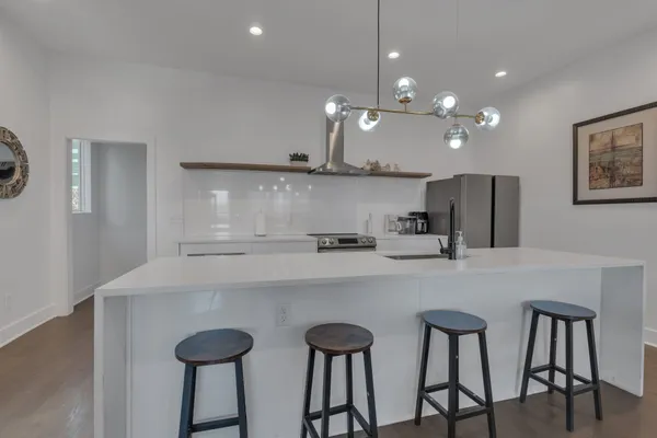 a kitchen with stainless steel appliances a table chairs refrigerator and microwave