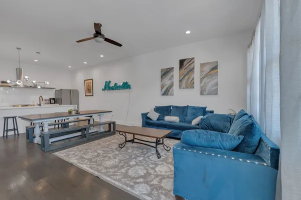 a living room with furniture and kitchen view