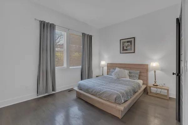 a bedroom with a bed lamp and a large window