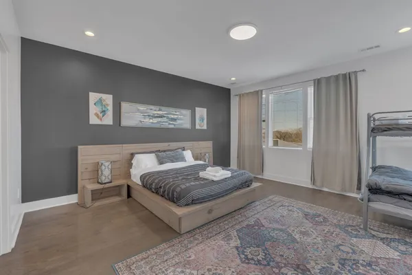 a bedroom with a bed and a painting on the wall