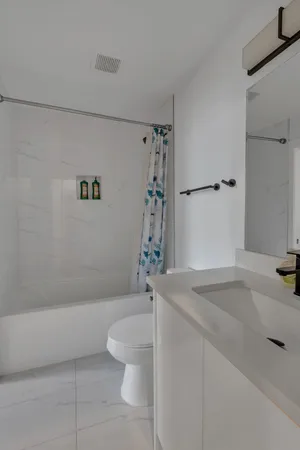 a bathroom with a granite countertop sink a toilet and bathtub