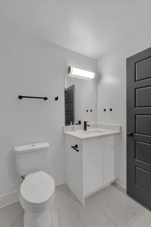 a bathroom with a toilet sink and mirror