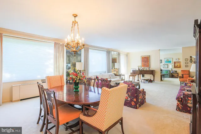 a dining room with furniture a chandelier and window