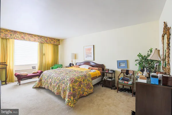 a bed sitting in a bedroom and a large window