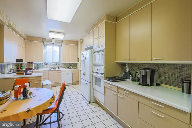 a white kitchen with a sink appliances and cabinets