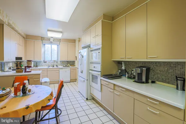a white kitchen with a sink appliances and cabinets