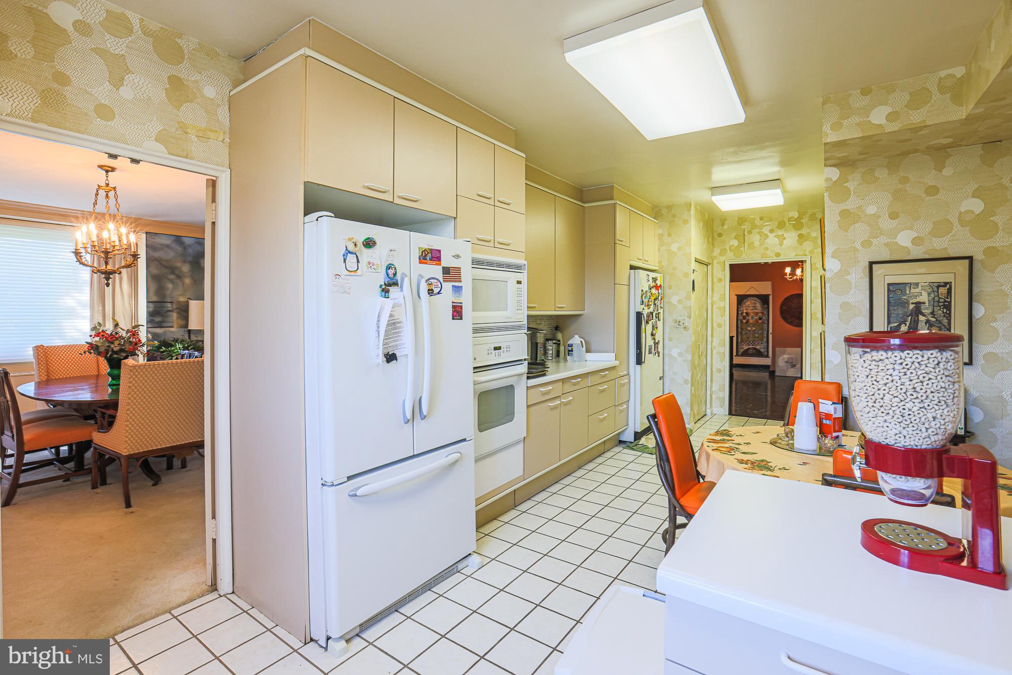 11 Slade Avenue, Unit 412 Baltimore, MD 21208 - Photo 9 of 37 a kitchen with stainless steel appliances a refrigerator and a dining table