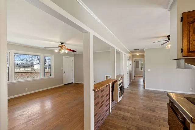 a view of a hallway with wooden floor and staircase