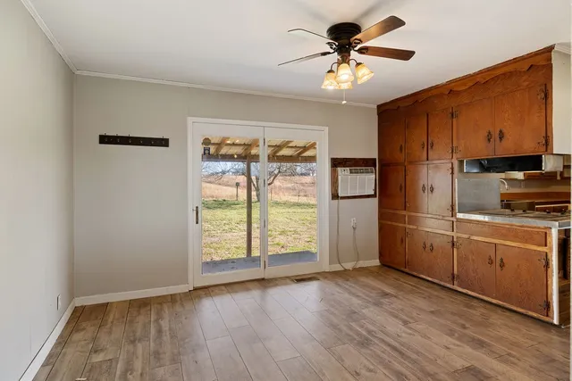 a kitchen with stainless steel appliances granite countertop a refrigerator a stove a sink and a microwave with wooden floor