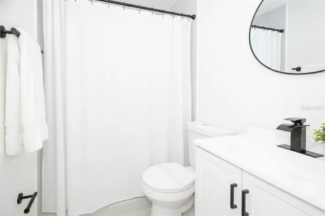 a bathroom with a sink toilet and a mirror