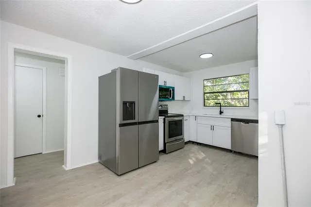 a kitchen with a refrigerator and windows