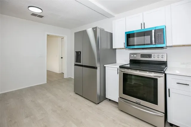 a kitchen with stainless steel appliances a stove a microwave and a refrigerator