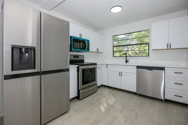a kitchen with white cabinets and white appliances