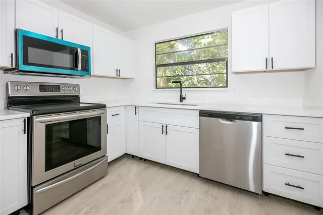 a kitchen with cabinets appliances and a sink
