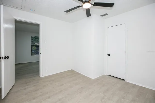 an empty room with a ceiling fan and carpet
