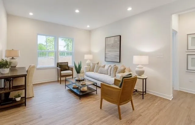 a living room with furniture and a wooden floor